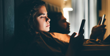 Digitální závislost - pár v posteli na mobilech