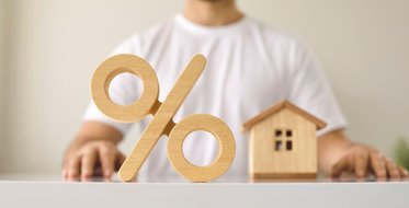 Jaké jsou úrokové sazby hypoték - dřevěná procenta a baráček na stole