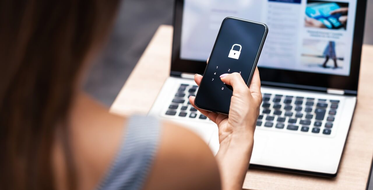Jak chránit své platební údaje - Žena s mobilem v ruce, zabezpečení, notebook na stole