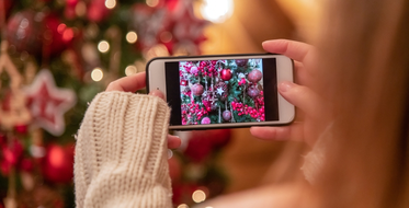 Žena fotí telefonem vánoční stromek