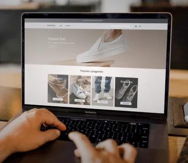 A laptop screen shows an online shoe store