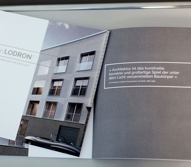 Ein geöffneter Folder zum Bauprojekt Wohnzone Paris Lodron 7 liegt auf einem Tisch