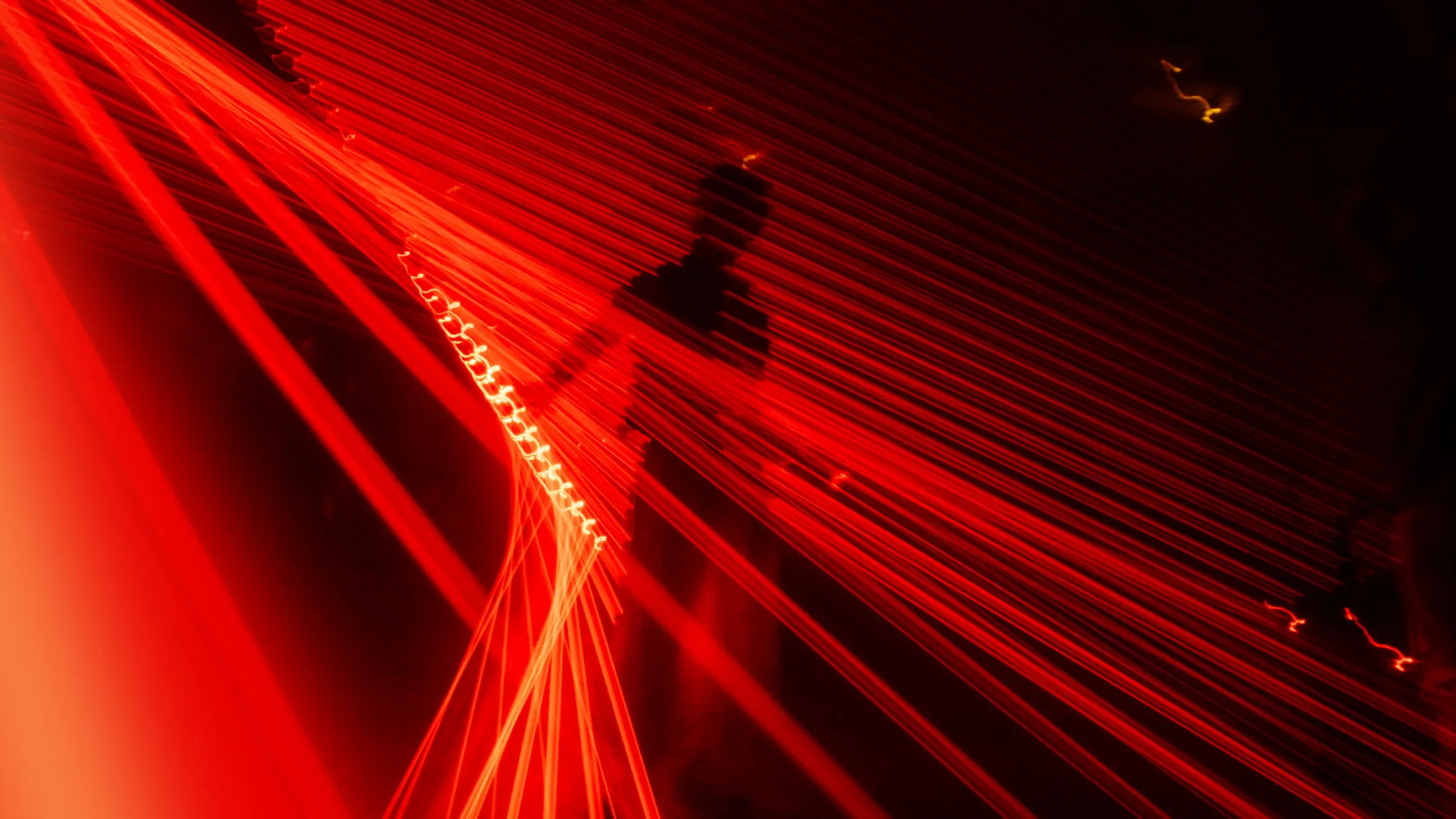 Red laser beams sweeping a dark venue, multi-sensory immersive brand experiences built around sound
