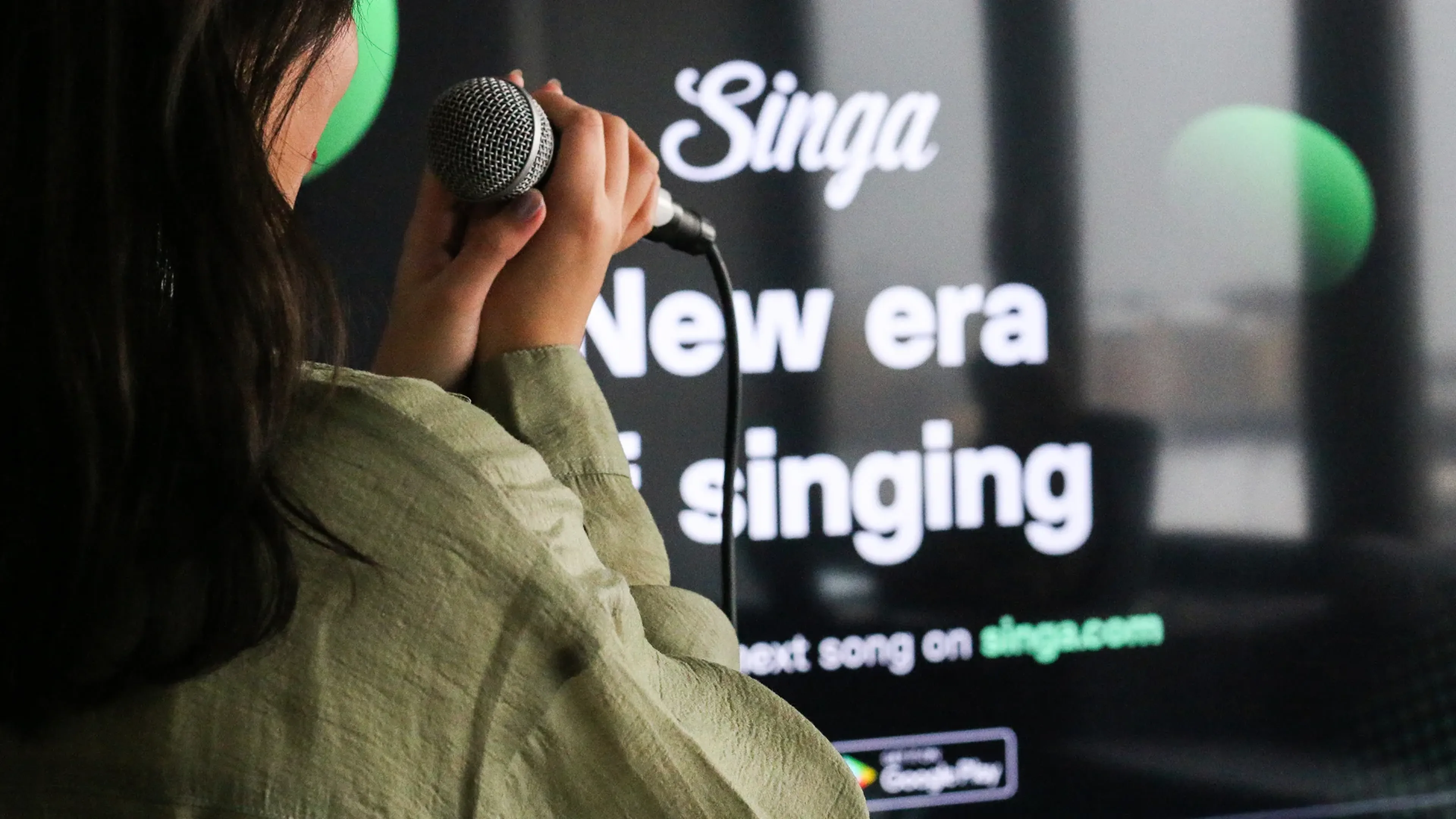Woman in headphones beside Singa New era of singing tagline, banner hero of the Singa karaoke case study