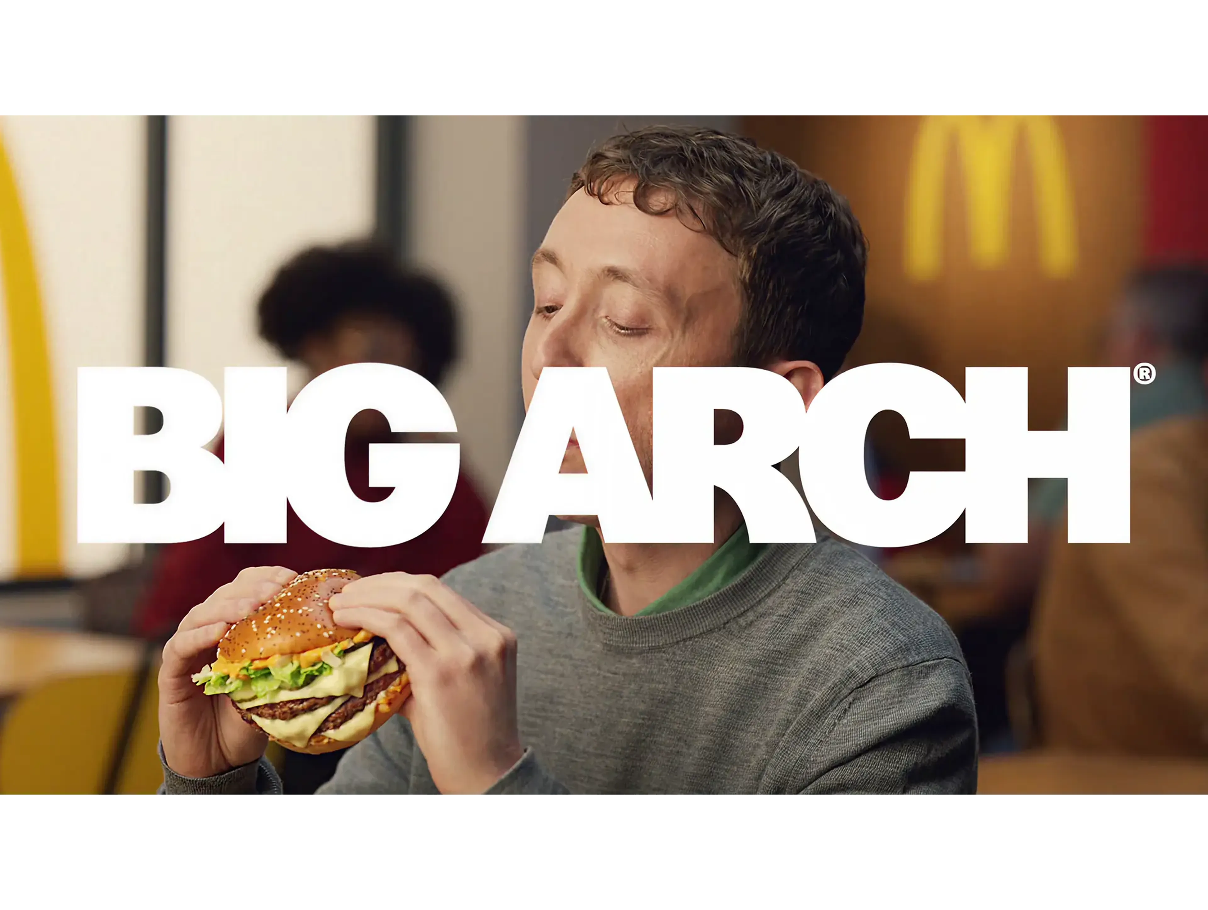 Big Arch title over a man eating a McDonald's burger by the golden arches, Sound of McDonald's