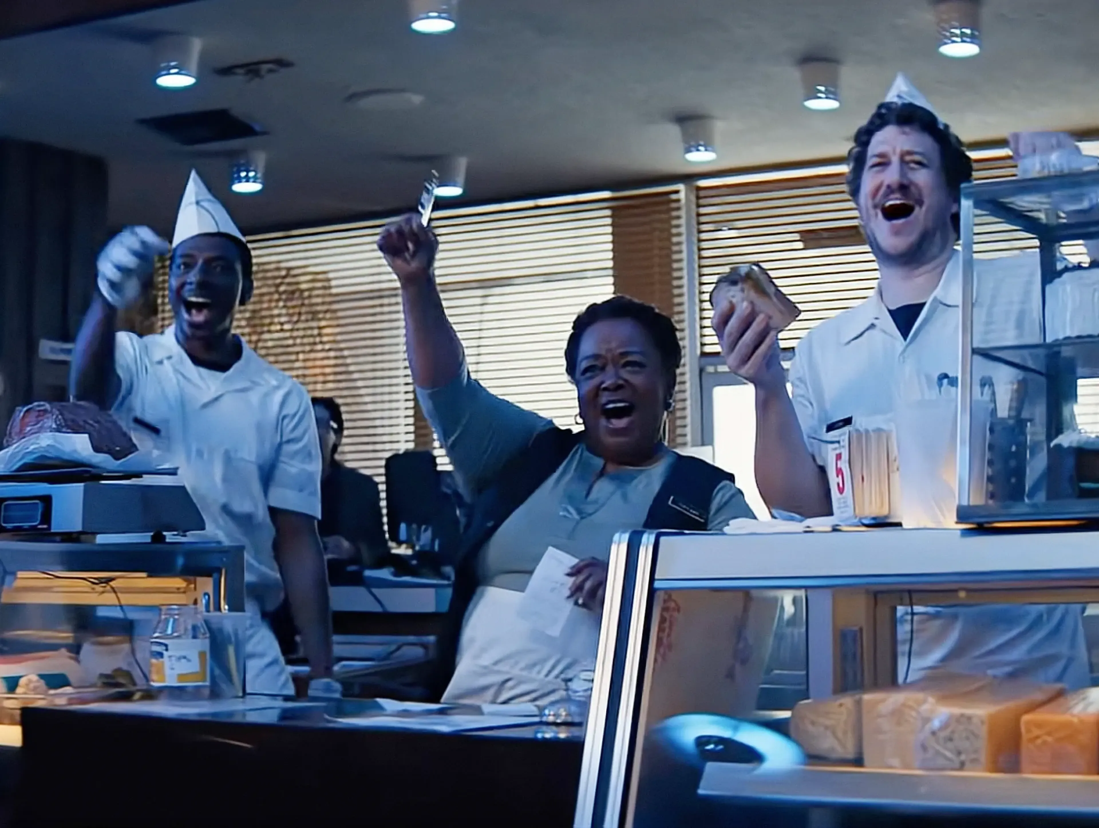 Deli staff in paper hats cheering behind the counter in the MassiveMusic Hellmann's Super Bowl campaign film