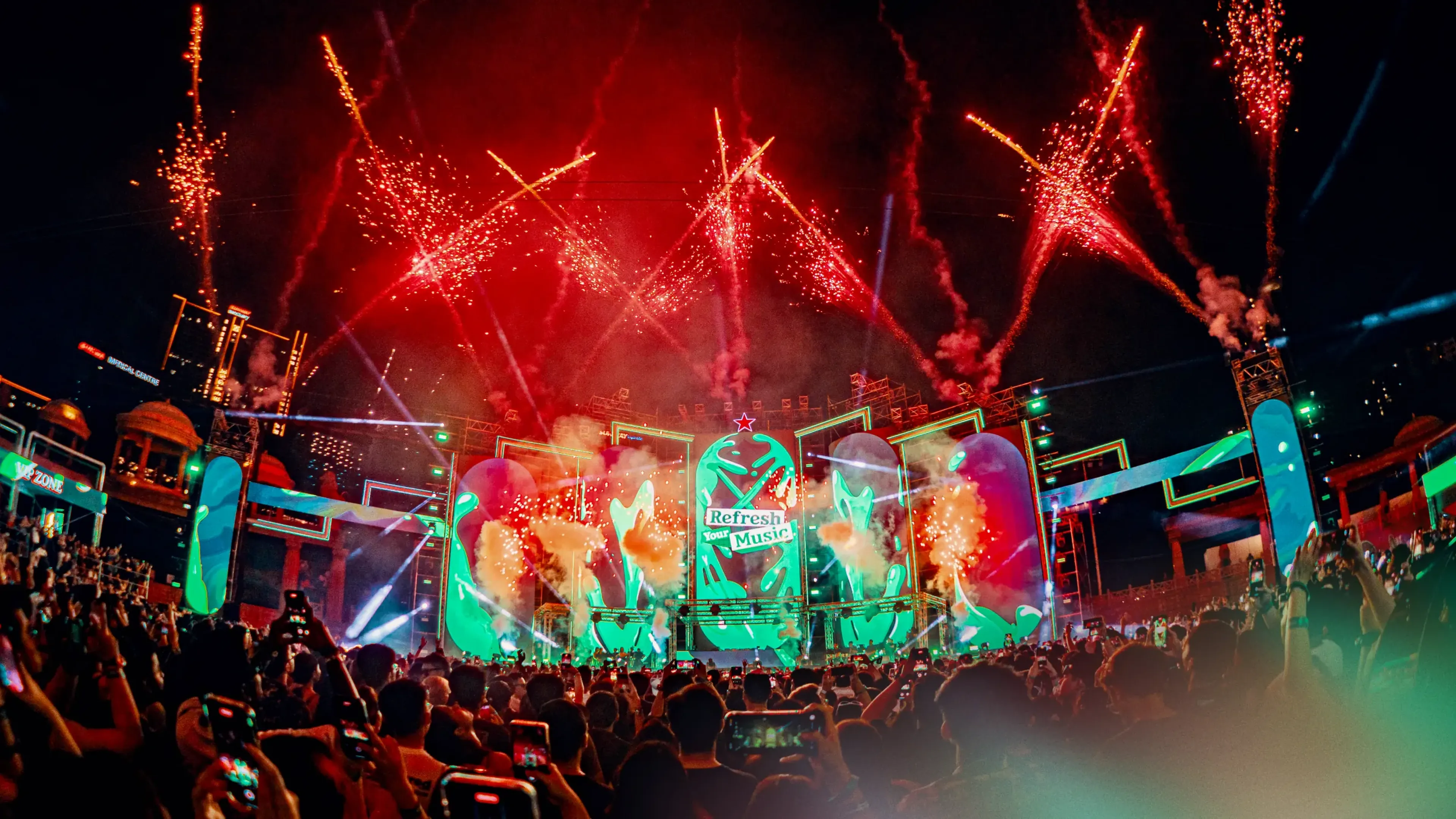 Crowd filming a festival stage lit by fireworks, the kind of unforgettable brand moment MassiveMusic helps create