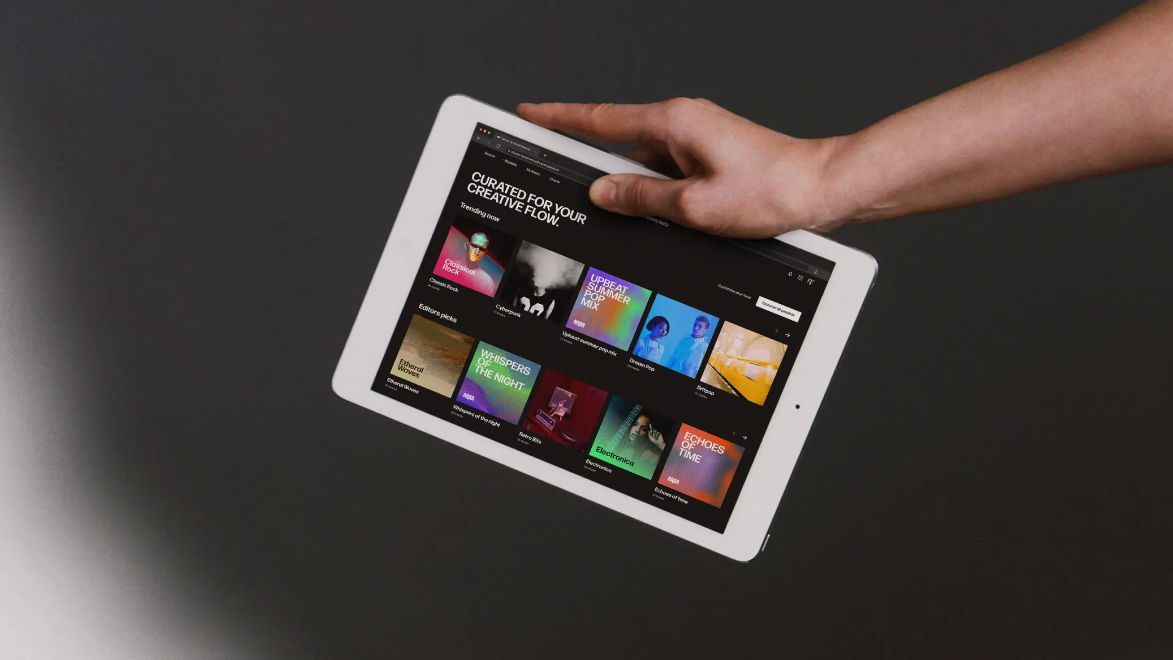 Hand holding a tablet showing a music streaming app, music infrastructure for digital platforms and apps