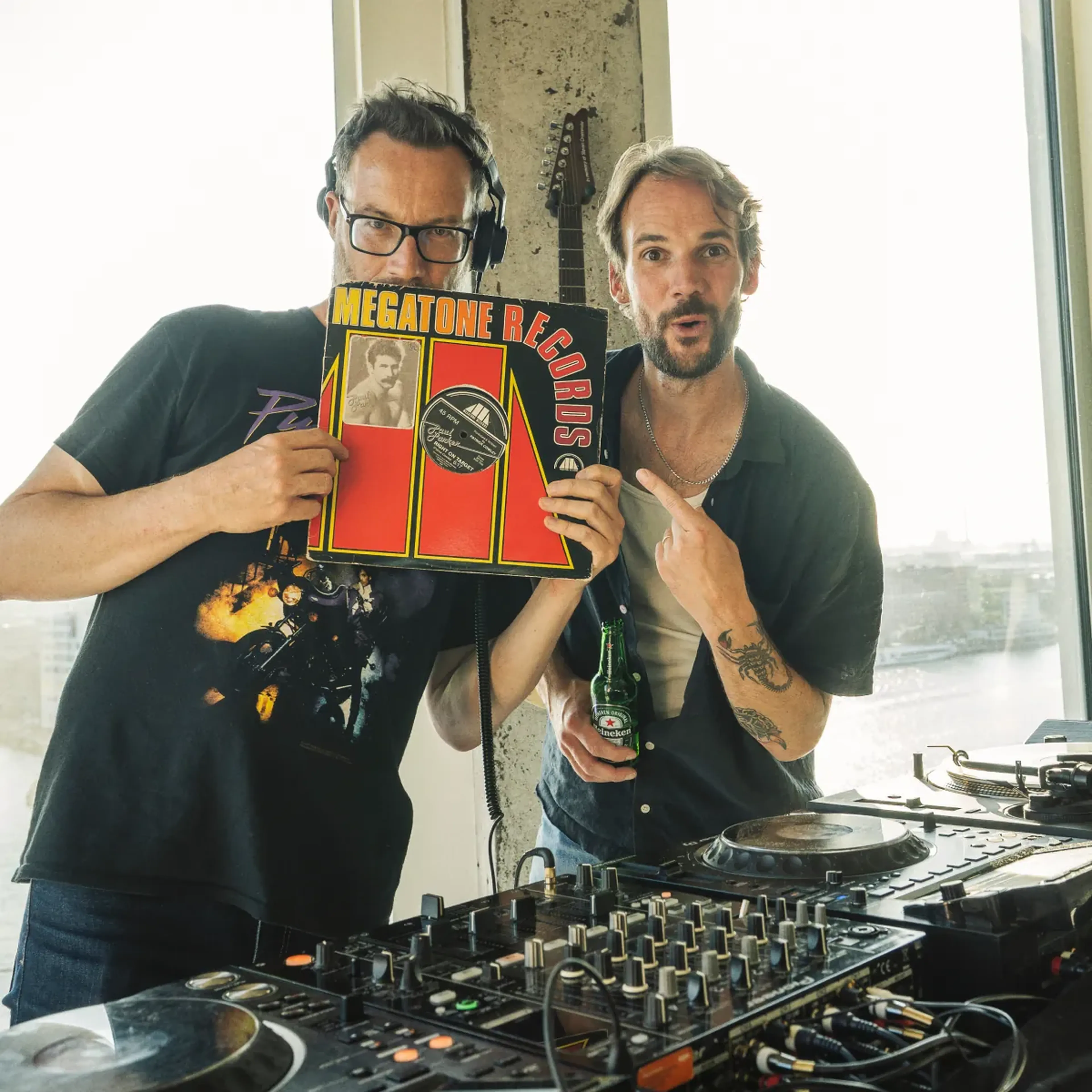 Two MassiveMusic team members at the decks with a vinyl record