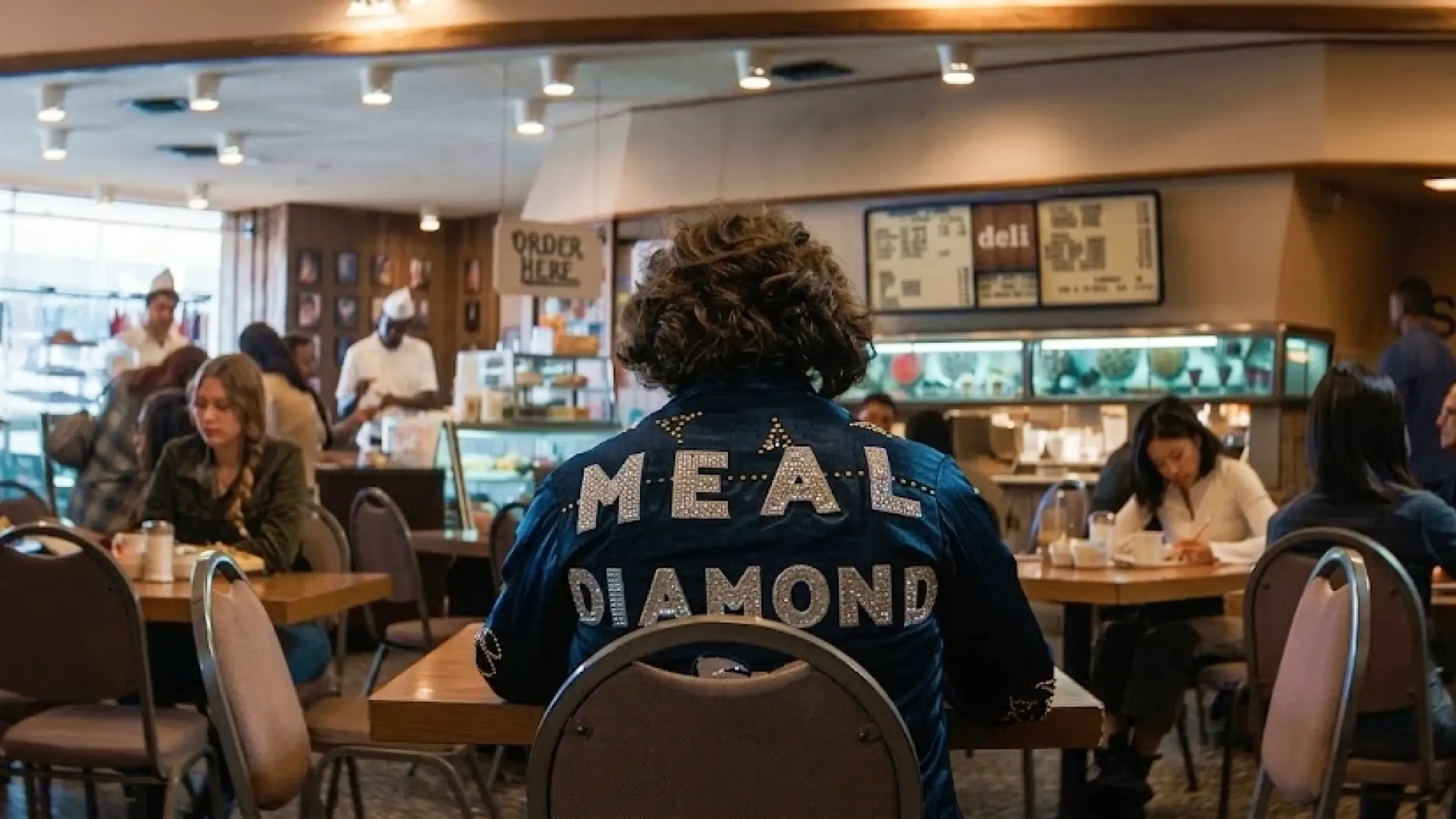 Diner scene from the MassiveMusic Hellmann's campaign, with a customer in a sequinned Meal Diamond denim jacket