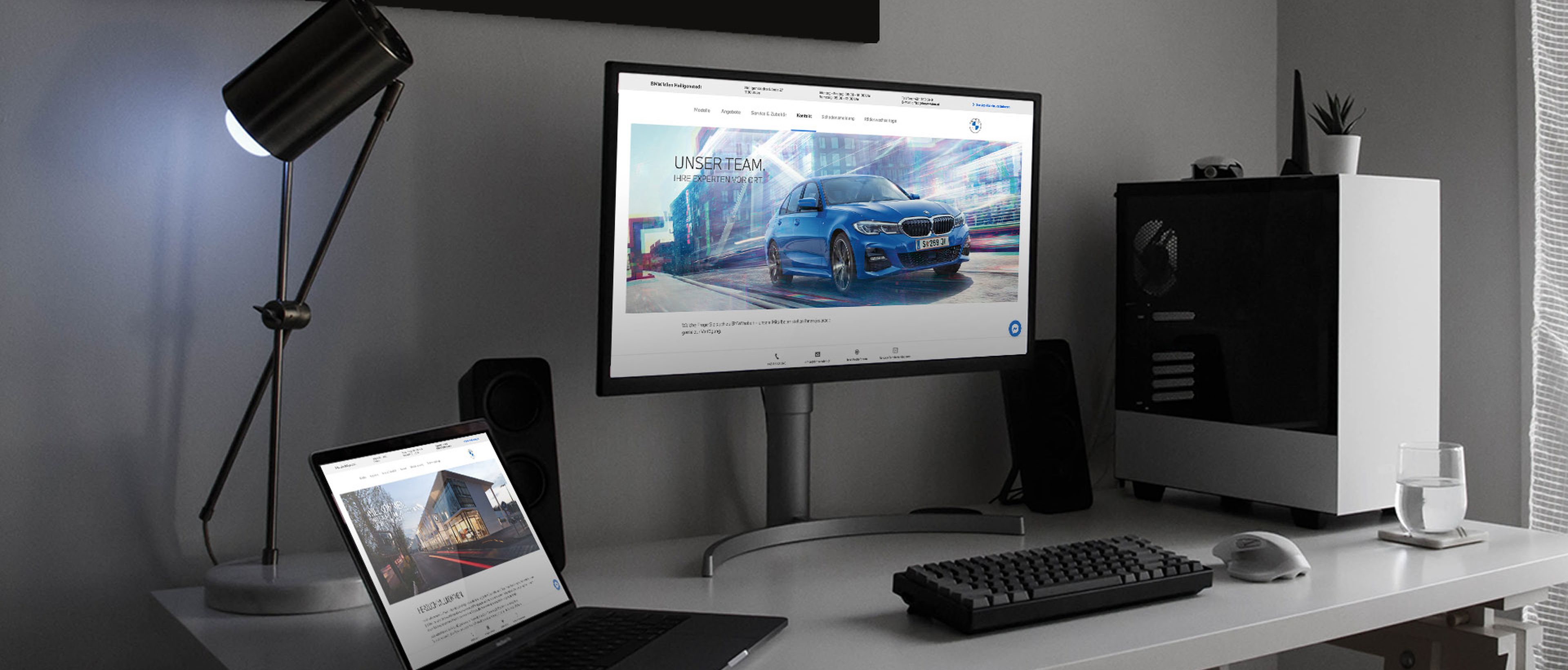 Schreibtisch mit Monitor und Laptop mit offener BMW Webseite