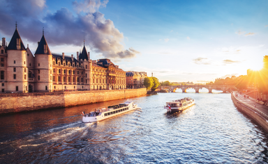 Dramatic sunset over river Seine in Paris, France, with Conciergerie and Pont Neuf. 