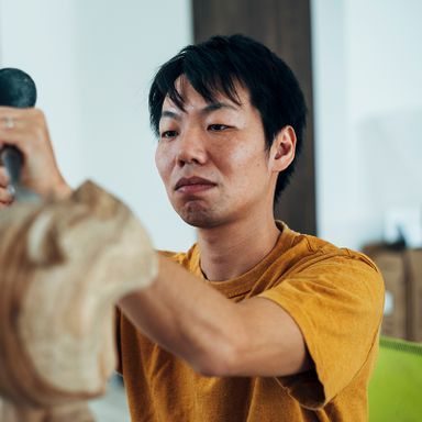 Satoru Koizumi concentrating on a sculpture in front of him