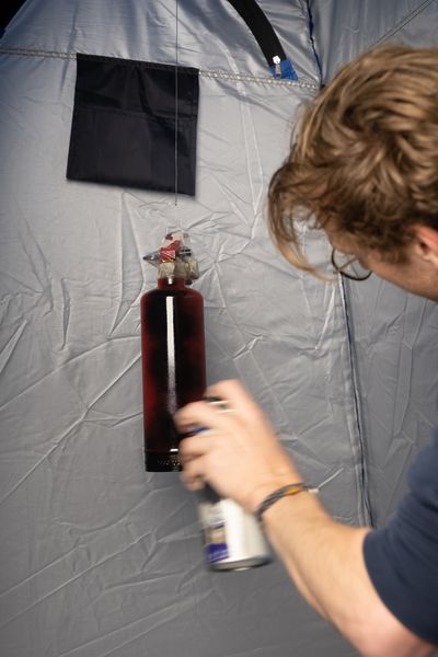Wout spray painting a fire extinguisher in Matte Black