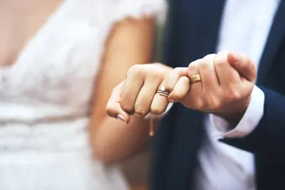 Ein Brautpaar zeigt seine angesteckten Ringe.