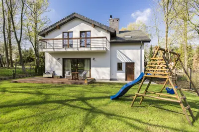 Ein Einfamilienhaus mit Garten, Terrasse und Klettergerüst