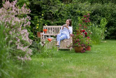 Umlegungsverfahren: Eine Eigentümerin sitzt in ihrem Garten.