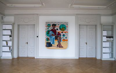 installation view of white white with a painting hung on it and two doors flanking it