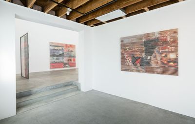 installation view of white walls with large weaves hung on them