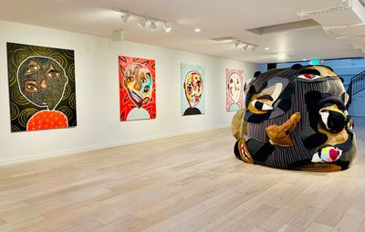 installation view of four paintings accompanied by a large three dimensional work