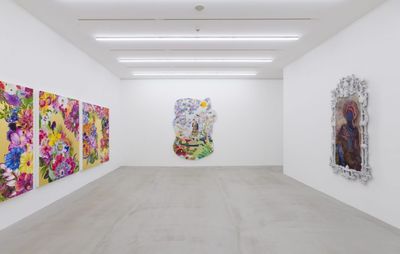 installation view of a white room filled with paintings by different artists