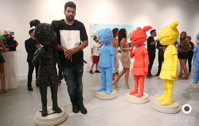 Hebru Brantley stood alongside four sculptures of children superhero characters in gallery space