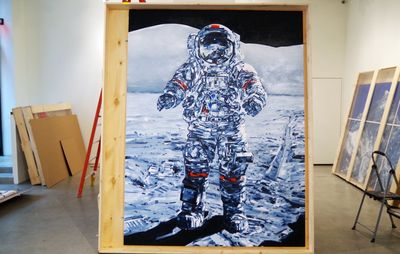 view of Michael Kagan large painting of astronaut stood up against wooden frame