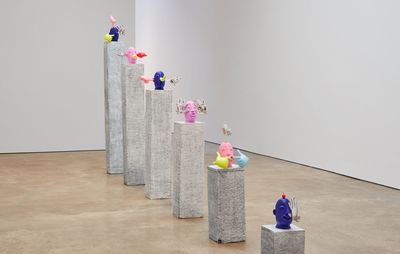 installation view of a row of plinths with sculptures of heads on them