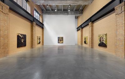 5 portraits painted on canvases covered with broken crockery, hung on 3 walls of a large industrial gallery space