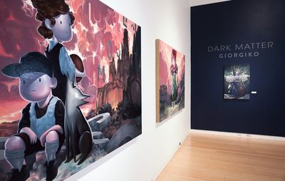 The entrance to Giorgiko's Dark Matter, solo show at Mesa Contemporary Art Museum, with two of their paintings hung on a white wall to the left, and another of a dog wearing a wide ruff collar on the dark wall at the back