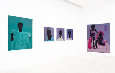 installation view of purple and blue portraits hung on white walls