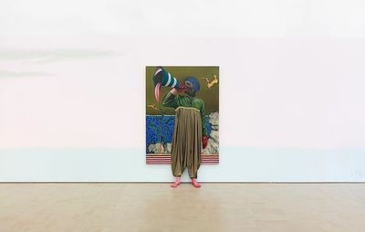 view of gallery wall, bare apart from a centrally positioned paintings with a three dimensional figure projecting from the picture plane and standing with their feet on the gallery floor