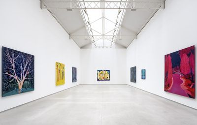 installation view of white exhibition space with seven paintings of varying sizes