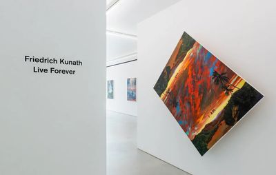 gallery view of exhibition title and on adjacent wall is a tilted sunset painting