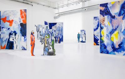 installation view of white exhibition space with six large freestanding, colourful paintings and several sculptures