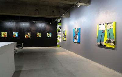 Installation view of grey walls with 8 cartoon paintings on