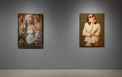installation view of two portraits hung on a grey wall