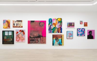 installation view of numerous brightly coloured paintings hung up