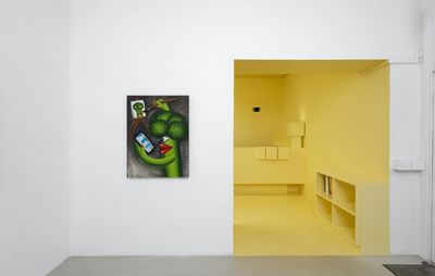 installation view of a broccoli painting hung on a wall next to a yellow entrance