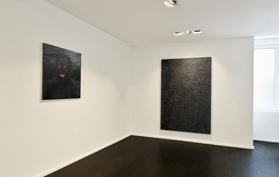 installation view of two dark paintings set against white walls