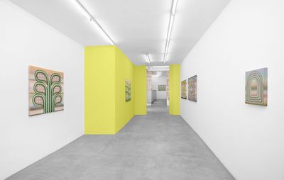 Artworks hanging in yellow and white gallery space