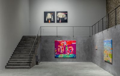 installation view of four large paintings hung in a multi-level gallery setting