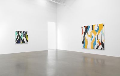 Two artworks hung on large white walls