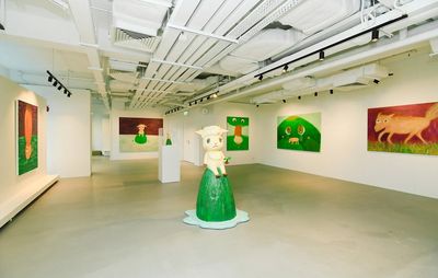 installation view of several cartoon-like paintings, all making use of a green colour palette, and a sheep sculpture in a gallery space