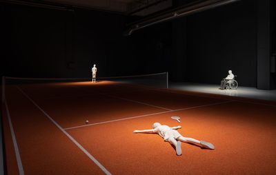 installation view of a tennis court installation with several white sculpted figures on it