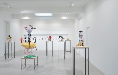 installation view of white exhibition room with six plinths of varying heights, all with sculptural characters on top of them