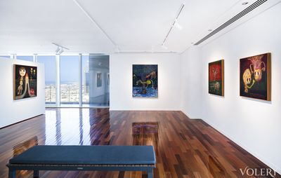 an installation view of large wooden glossed floors with four paintings hanging