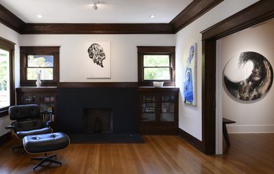 installation view of domestic interior with three paintings spread out on the walls amongst other furniture