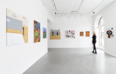 an installation view of a variety of paintings by different artists hung on white walls