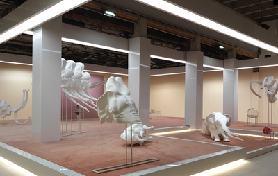 installation view of a brightly lit square platform holding various freestanding sculptures